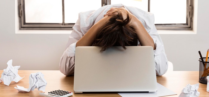 Mulher exausto no local de trabalho, com sinais de burnout